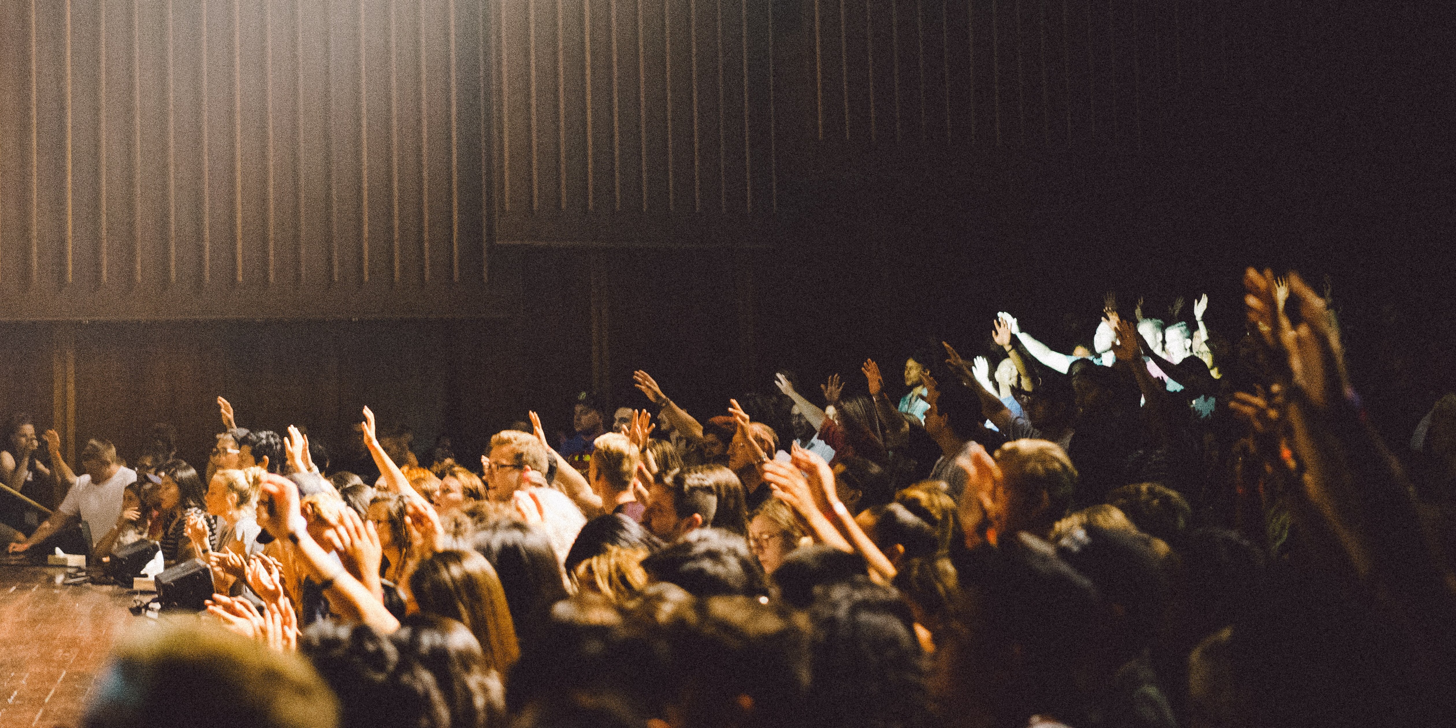 how can you collaborate? people in a huge meeting - hands up